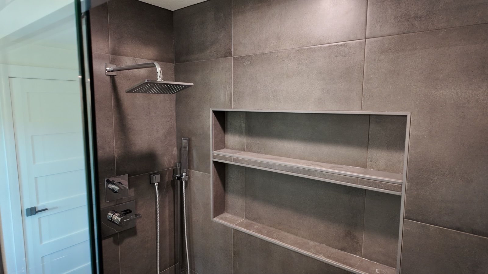Tiled walk-in rainfall shower in a full bathroom