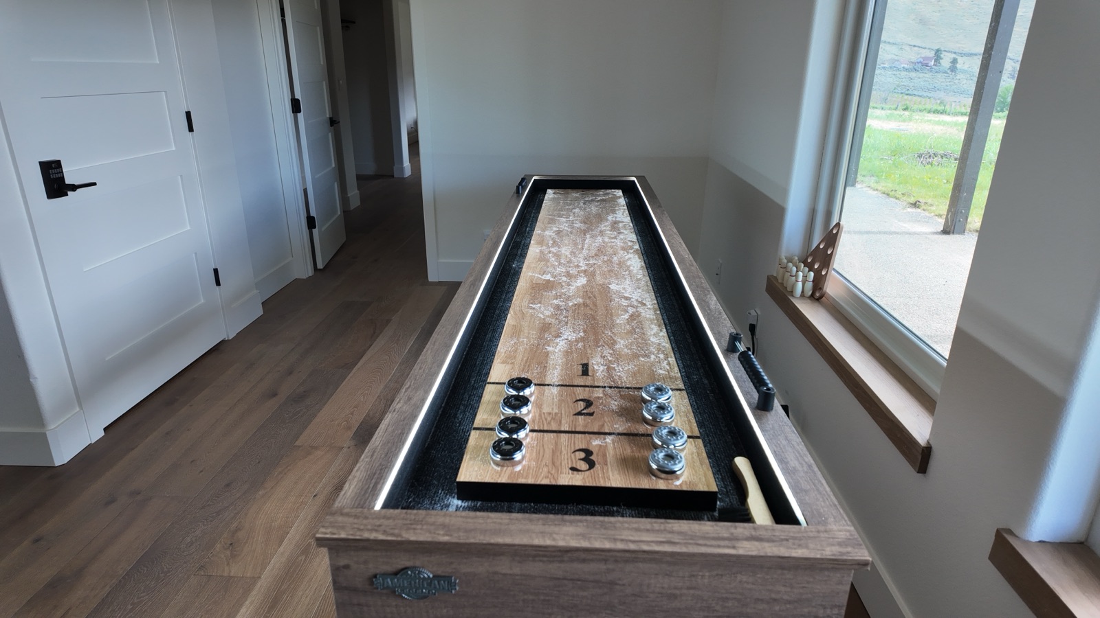 Game room with a shuffleboard table, deep sectional sofa and smart TV